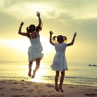 儿童跃起系列之两个在海边开心跃起的小女孩