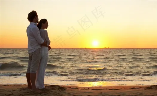 海边夕阳下拥抱的情侣图片