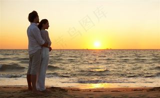 海边夕阳下拥抱的情侣图片