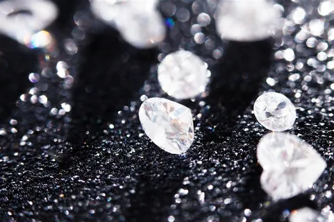 黑色光斑粒子背景上的心形水晶钻石高清图片