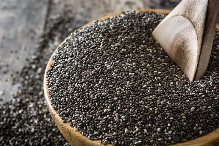 木碗里的黑芝麻和散落的芝麻高清图片