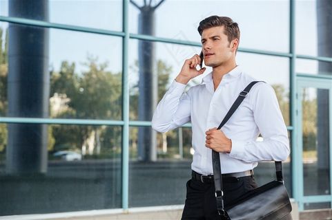 挎着公文包打电话的商务人士