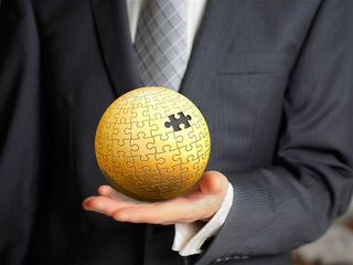 商务人士手上残缺的金色圆形拼图模型高清图片职场人物