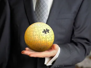 商务人士手上残缺的金色圆形拼图模型高清图片职场人物