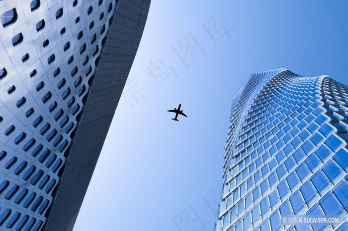 从高楼大厦之间飞过的飞机图片