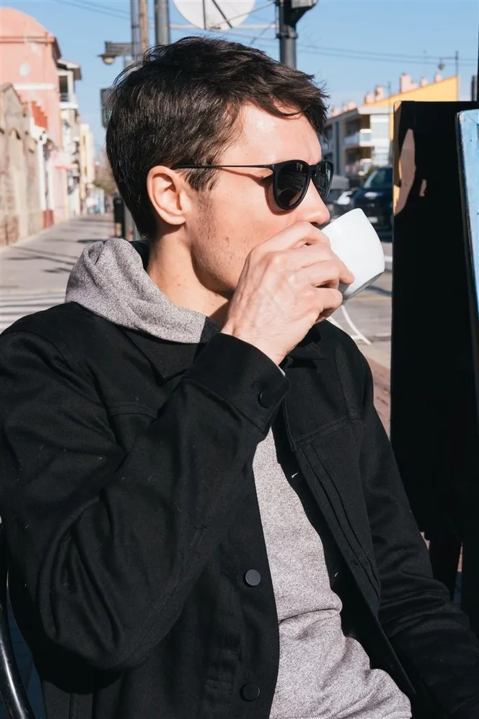 正在喝咖啡的男人坐在街边