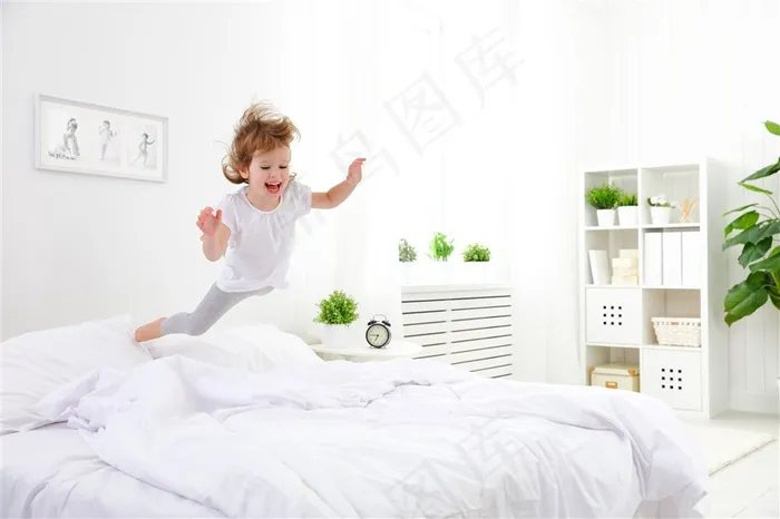 在床上跳跃的金发女孩高清摄影