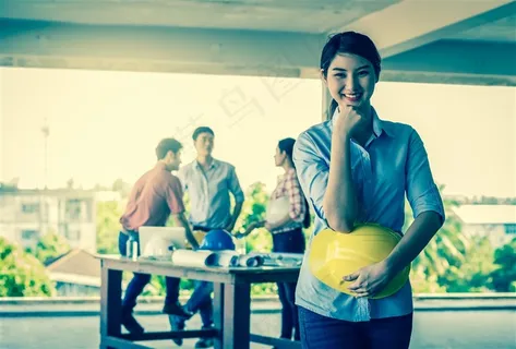 抱着安全帽微笑的美女工程师高清图片