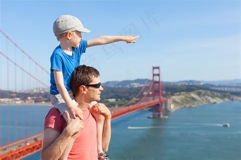 骑在父亲背上眺望远方的小孩