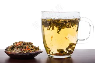 木桌子上的茶叶跟一杯茶