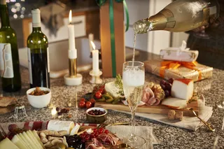 餐桌上摆着西餐和正在倾倒香槟