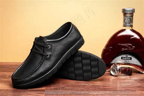 台子上杨酒瓶旁的黑色男士皮鞋图片欣赏