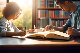 图书馆里坐着长桌学习的学生被阳光照射下摄影图