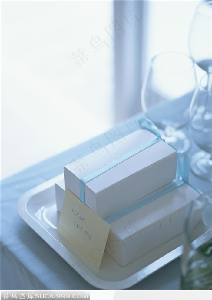 托盘里的礼品盒与桌子上的玻璃酒杯