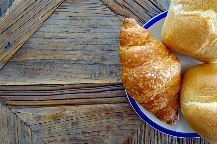 木板背景美味牛角面包早餐图片