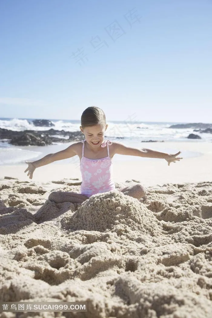 在沙滩上玩沙子的小女孩