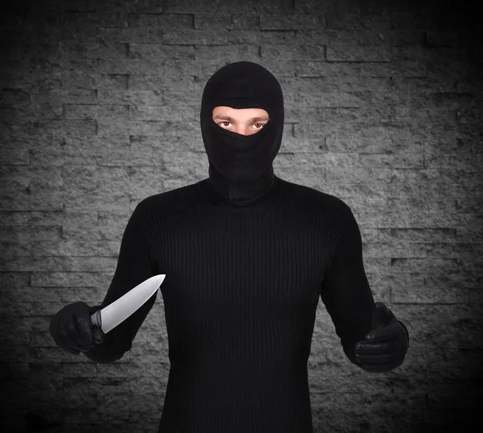 灰色背景下的持刀男子高清摄影