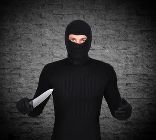 灰色背景下的持刀男子高清摄影