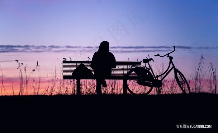 黄昏坐在湖边长椅上的人物风光自行车
