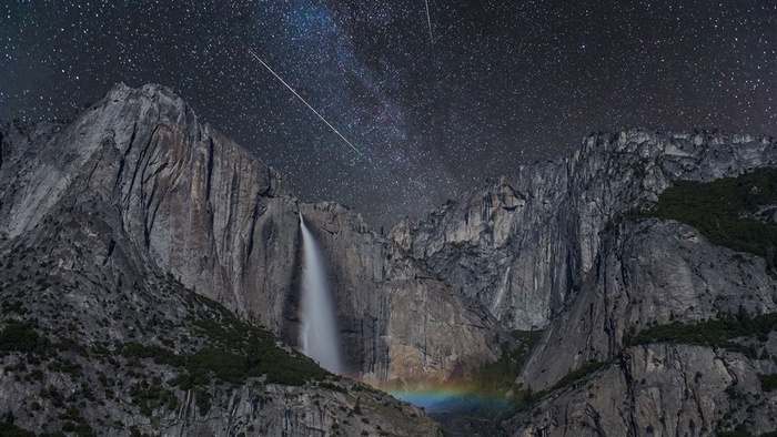 流星划过黑色天空下的高山