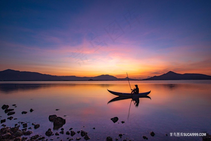 唯美夕阳晚霞水天一色湖面的小船风景摄影