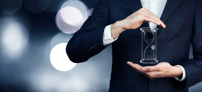 穿黑色西装的商务人士手中的沙漏高清图片 穿黑色西装的商务人士手中的沙漏高清图片
