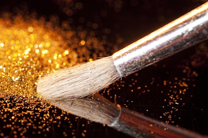 桌子上的白色笔刷和金粉高清摄影图片