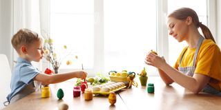 复活节母亲和孩子一起在窗边画彩蛋