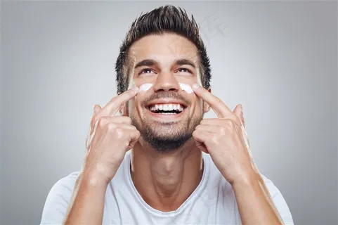 面部涂抹着护肤品微笑的男士高清图片