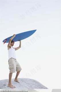 把蓝色冲浪板举在头顶的外国男人