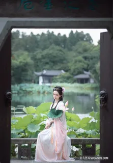 粉红衣着荷花池塘边的古装写真女子图片