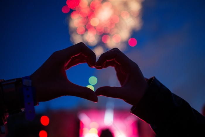 夜色中的霓虹灯和爱心手势高清图片