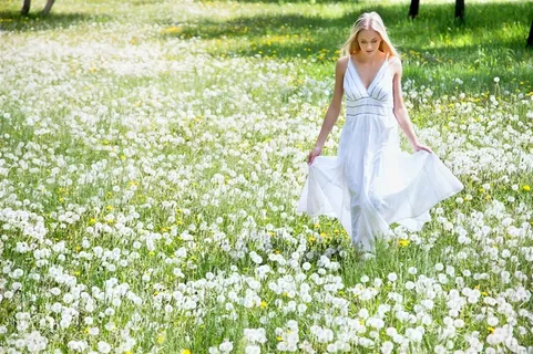 白色长裙美女走在蒲公英花丛中图片