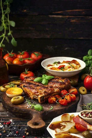 美食餐桌餐厅，烤肉披萨西餐水果红酒摄影图