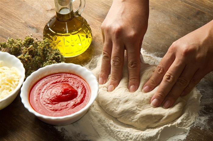 正在木桌做做面团的双手