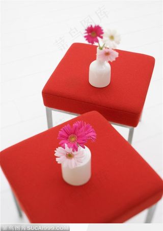 两把红色的小方凳和花瓶里的鲜花