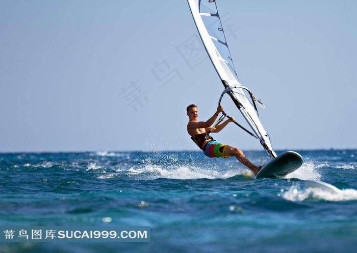在大海上激情玩帆板的运动员特写图片