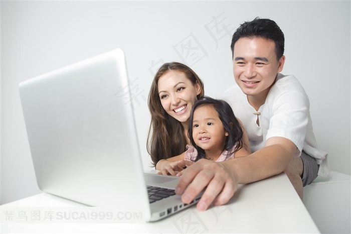 在玩电脑的一家三口人特写摄影高清图片