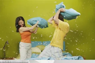 家中生活-在床上拿枕头打架嬉戏的外国夫妻两