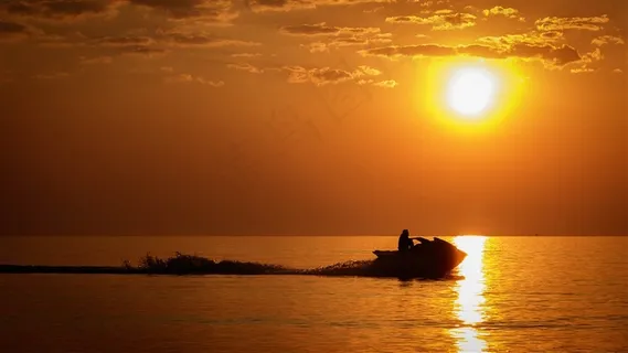 落日下行驶快艇的男人