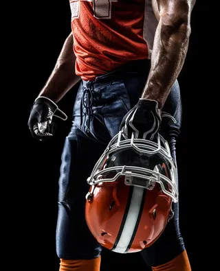 拿着头盔的橄榄球运动员