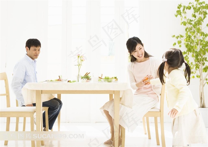 饭桌前小女孩给妈妈拿水果