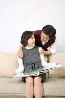 坐在沙发上看相册的夫妻