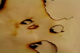 燃烧成洞的纸张图片