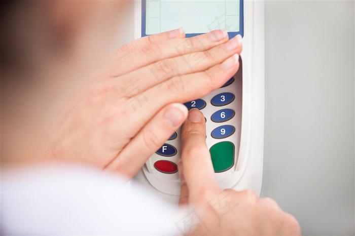 正在pos机上用手挡住按键输密码的人高清图片