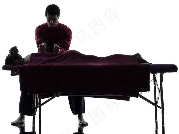 正在给躺在按摩床的女性按摩的按摩师高清图片