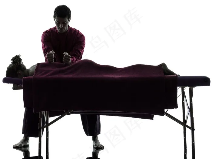 正在给躺在按摩床的女性按摩的按摩师高清图片