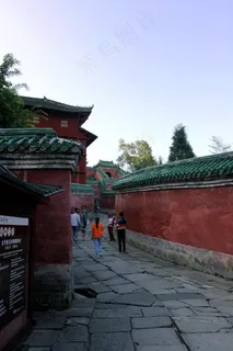 蓝天下红色围墙间的道路