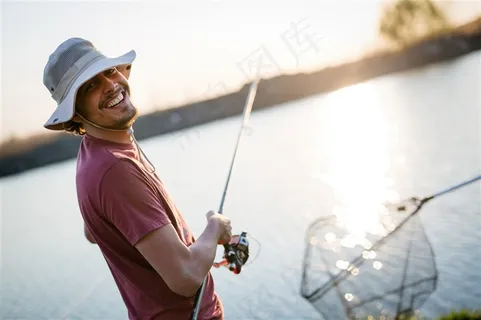 湖边钓鱼转头微笑的男人高清图片 湖边钓鱼转头微笑的男人高清图片