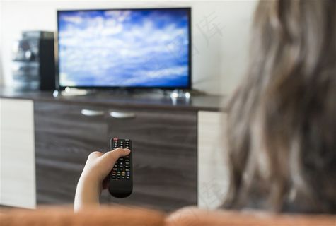 手拿遥控看电视的女人高清图片